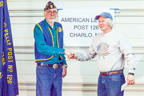 Commander Ken Soester, left, presents a $1,000 check to Montana Wounded Warriors trustee Neil Baumann