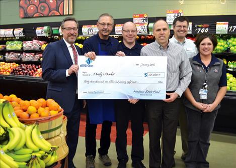 Laurence “Lanny” A. Hubbard, left, Montana State Fund president/CEO, presents a $33,010.78 dividend check to Greg Hertz, CEO of Moody’s Market Inc. Jan. 6 at Super 1 Foods. Also pictured are Bob Howell, produce manager; Gary Collinge, store manager; Rob Turner, PayneWest; and Nicole Miller, front end manager.