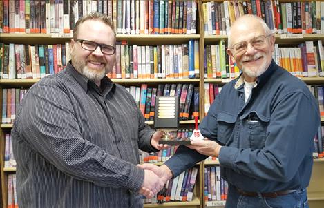 Chriss Sopke, pastor of New Life Christian Church in Polson, hands off the Bell Ringing Trophy to Pastor Russ Barber of Polson Community Church.