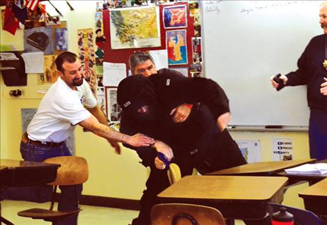 Teacher Lyle Cronk and Principal Dan Durglo practice taking down a mock intruder provided by Lake County Sheriff's Office.