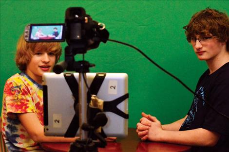 Kenna Ferril and Gabe Moxness record a segment for the school news.