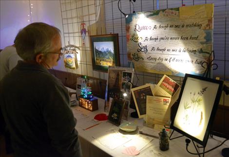 Supporters of the arts peruse silent auction items at the Ninepipe Arts Group fundraising Valentine party.