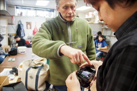 Photography instructor David Spear helps Two Eagle River School student Lee Atwin load film in a 35mm camera.