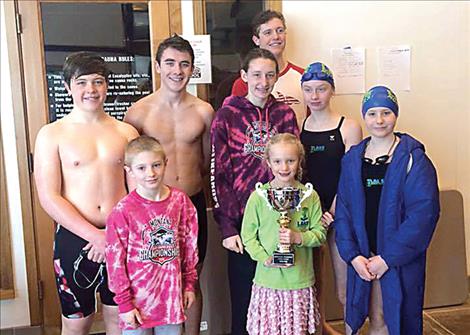 Lake Monsters Gabe Mergenthaler, Landon Shipley, Elissa Crist, Tiana Crist, Hannah Simpson, Amelia Stene and Teague McElwee and Missoula YMCA swimmer Jacob Butler hold the 2016 Montana Swimming Food Drive trophy.