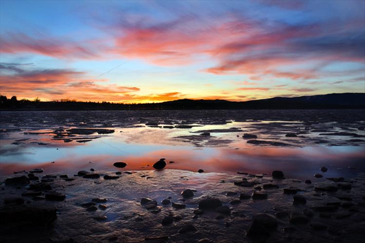 Melting ice water reflects the warm colors of sunset