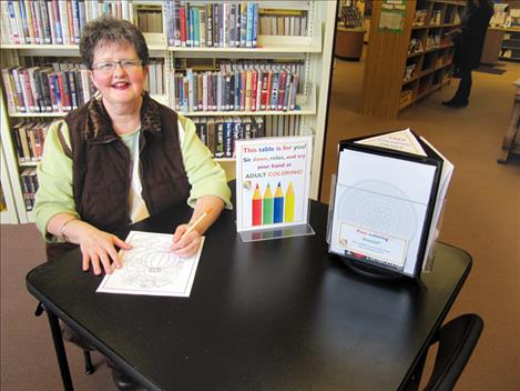 Courtesy photo Public Services Librarian Angela Claver takes a moment from her busy day to try out the new adult coloring activities at North Lake County Public Library.