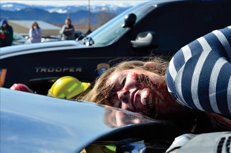leila Marsh lies dead on the hood of a car during a mock accident.