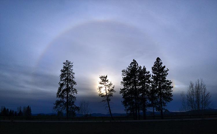 Sun dogs, a pair of bright spots on either side of the sun created by ice crystals interacting with light, are encircled by a 22 degree halo.