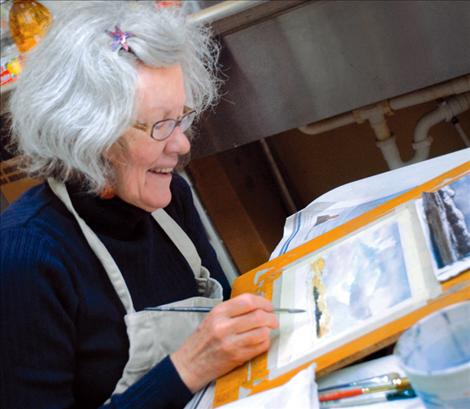 Watercolorist Jean Stromnes paints  a landscape and answers questions during the Dec. 7 art walk in downtown Polson.