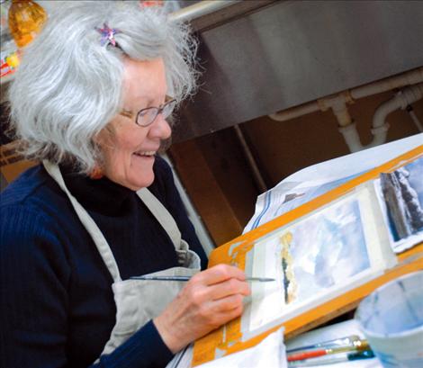 Watercolorist Jean Stromnes paints a landscape and answers questions during the Dec. 7 art walk in downtown Polson.
