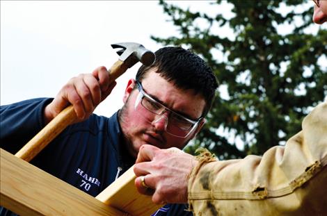 Christopher Hahn concentrates on hammering a nail into the pavilion.