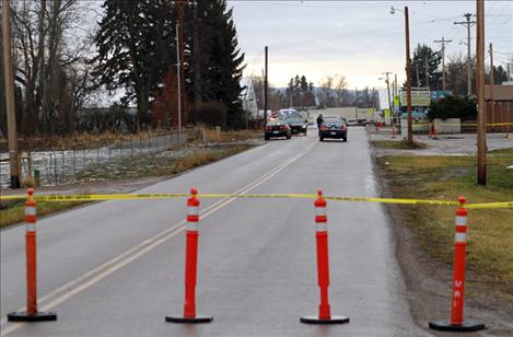 A portion of Third Avenue in Ronan is marked as a crime scene as law enforcement officers investigate the death of a older male whose body was found sometime Tuesday night in a parking lot near the Valley Club.