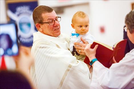  the baptism of  little Simon Brenner is celebrated on Easter at St. Andrew’s Episcopal Church, where grandparents “Face Time”  the baptism to relatives in Kentucky through their smart phones .