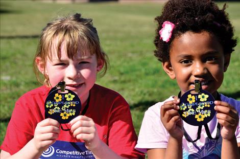 Karen Peterson/Valley Journal Proud finishers Kathleen Tanner, 7, and Eva Burton, 5, hold their medals.