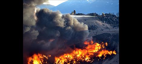 Firefighters put water on a fire burning in a pit of used and shredded tires at Tire Depot along U.S. Highway 93 in Pablo.