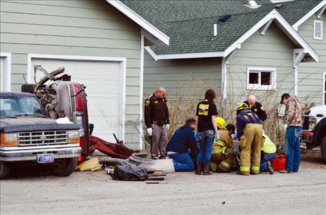 Emergency crews help one of the injured victims that was in the maroon car when it crashed.  