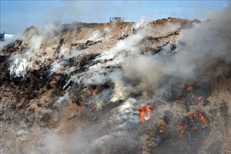 A bulldozer attempts to cap the fire with clay.