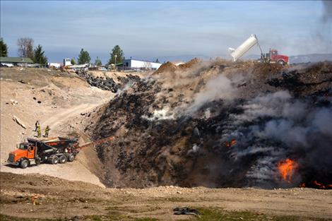 Loads of clay mixture are poured into the pit to smother the flames.