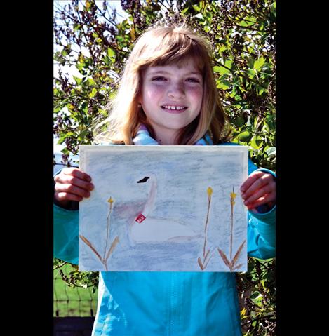 Lina Sturman, 9, holds her winning drawing of a swan. 