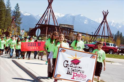 Students line up on the walking path bridge during the Graducation Matters parade.