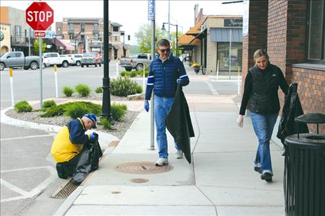 City Commissioners Ken Siler, left, and Todd Coutts pick up trash downtown with Mayor Heather Knutson.