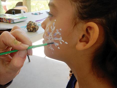 Avia Lee sits patiently as she gets her face painted.