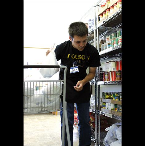 ohn Bakerstreet helps restock shelves at Polson Food Pantry.