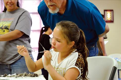 Jacelyn Charlo, 7, finds mouse bones in a bird pellet. 