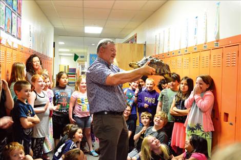 Although he admits he has a reptile phobia, Linderman Principal Tim Finkbeiner cautiously holds the tortoise during its visit to the school.