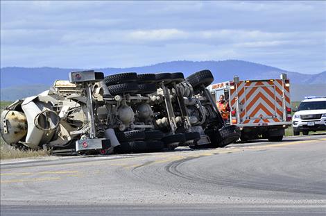 A full cement truck sits on its side after turning westbound onto Highway 212 Friday afternoon.