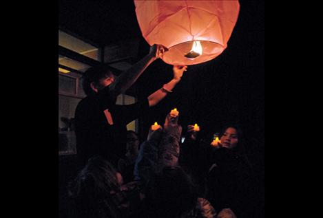 Cherry Valley students hold their battery-powered lights up to the sky lantern as a parent steadies the paper craft before it drifts into the sky.