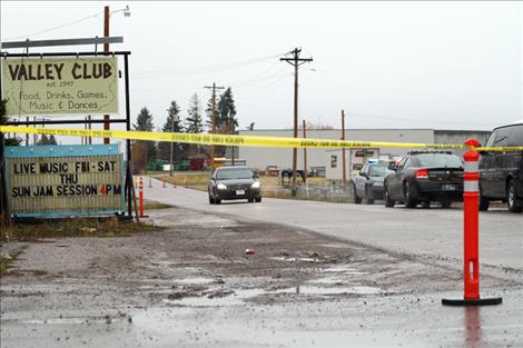 A portion of Third Avenue in Ronan is marked as a crime scene as law enforcement officers investigate the death of a older male whose body was found sometime Tuesday night in a parking lot near the Valley Club.