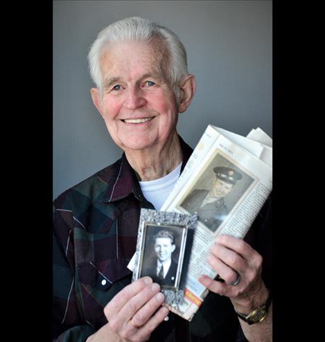 Tom Needham holds photos of his brother, Robert.