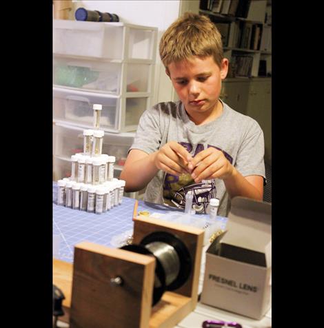 Brock Sturm, center, helps assemble a GearPod survival kit in his family basement.