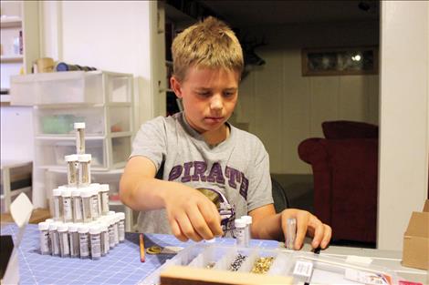 Brock Sturm, center, helps assemble a GearPod survival kit in his family basement. 