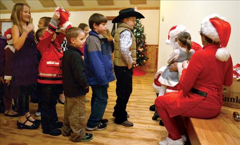 Children try to be patient as they wait to talk to Santa at the North Crow Clubhouse.