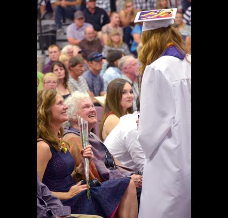 Graduates hand out roses to family members after receiving their diplomas.