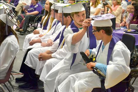 Charlo High School graduated 25 students Saturday, including Dominic Shively, right, getting his tassel straightened by a classmate.