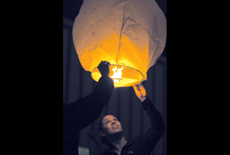 Ashleigh Lynch sends a Chinese lantern into the night sky last Wednesday night as many of her classmates and fellow residents followed suit. Ronan High School teacher Bonnie Eva said the event was planned and organized in part by Ronan High School's student council.  "It's a remembrance for anybody you couldn't see over the holidays," Eva said. "Whether they've passed away; just couldn't be here; are on active duty service overseas or they're just many miles away." Ronan resident Emosi Tatukivei and daughter Adriana were on their way home when they saw the lanterns floating toward the mountains over U.S. Highway 93. Emosi said he first thought they were helicopters.  "This is really cool," he said. "What a great way to celebrate." 