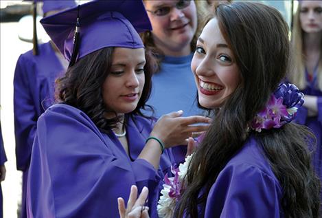 Stormie Cenicola, left, helps Janissa Stiles adjust a lei that Janissa’s grandfather shipped from Hawaii. “It’s a family tradition,” she said.