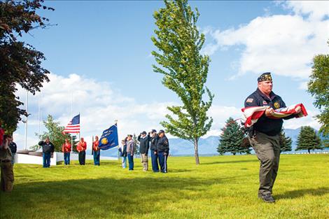 With the ceremonial flag inspection complete, Russ Harbin walks the first flag to the incinerator.