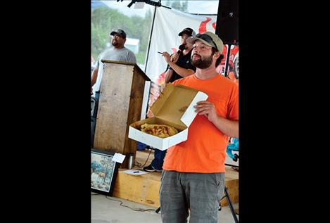 Fire Department Captain Joe Mitchell holds up a pie for people to bid on during the auction.