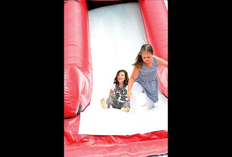 Children slide down the jumpy toys during the picnic.