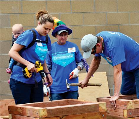 Brooke Roberts helps build storage containers with a companion on her back.