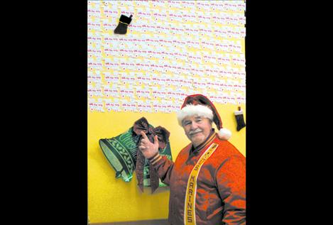 Frank Butler gestures toward a wall at Super 1 Foods in Polson containing Lake County residents’ donation trains.