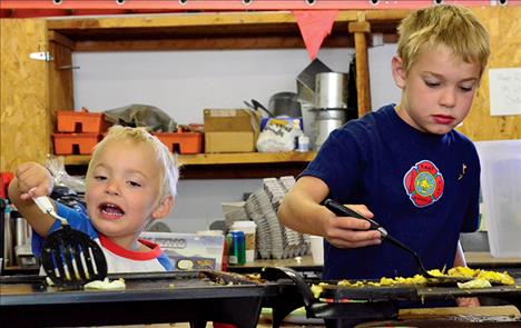 Brothers Caleb Clark, 4, and Caydan Clark, 9, help cook eggs at the Fireman’s Picnic Breakfast in Arlee. The brothers are grandchildren of former Arlee fire chief Don Henderson, who passed away last year.