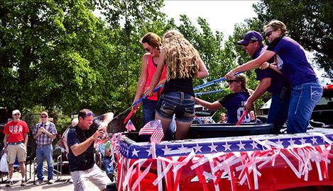The Charlo 14U softball team doused parade growers with water on the warm day.