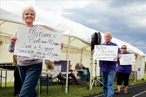 Barbara Moran, above, takes a victory lap with fellow cancer survivors at the start of the Lake County Relay for Life. Top left, a luminaria bag honors Bill Bishop, and below left, Tyneesha Brown stops briefly to pick up a lap marker.