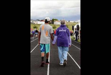 Darian Williams walks the survivor lap with his grandmother, Nancy Williams, druing the 2016 Lake County Relay for Life event July 8 in Polson.