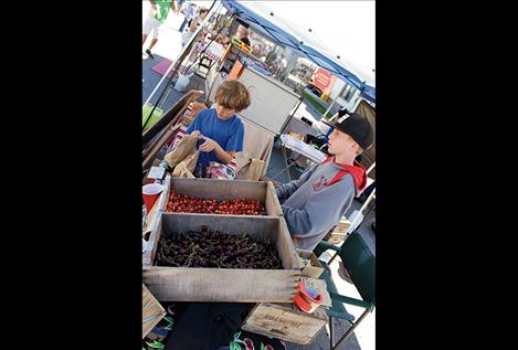 Jeremy Cromwell, left, sells cherries from their family orchard with the help of friend Carter Rawson.